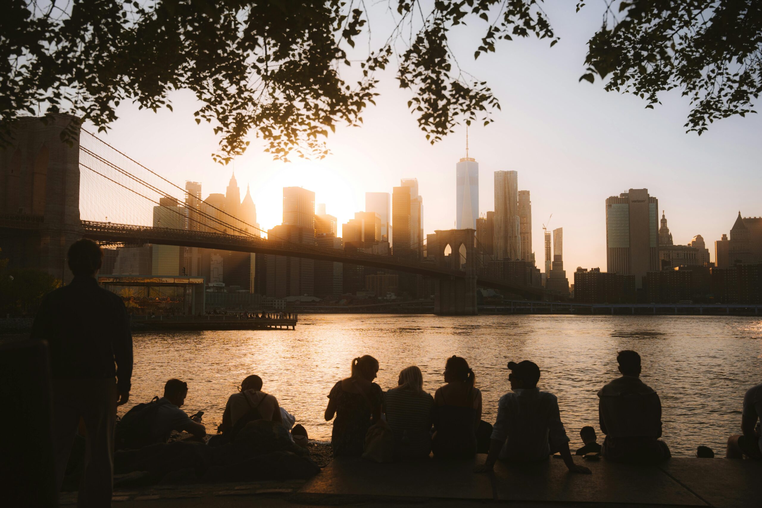 Group Looking at Illuminated NYC Downtown and Brooklyn Bridge at Dusk