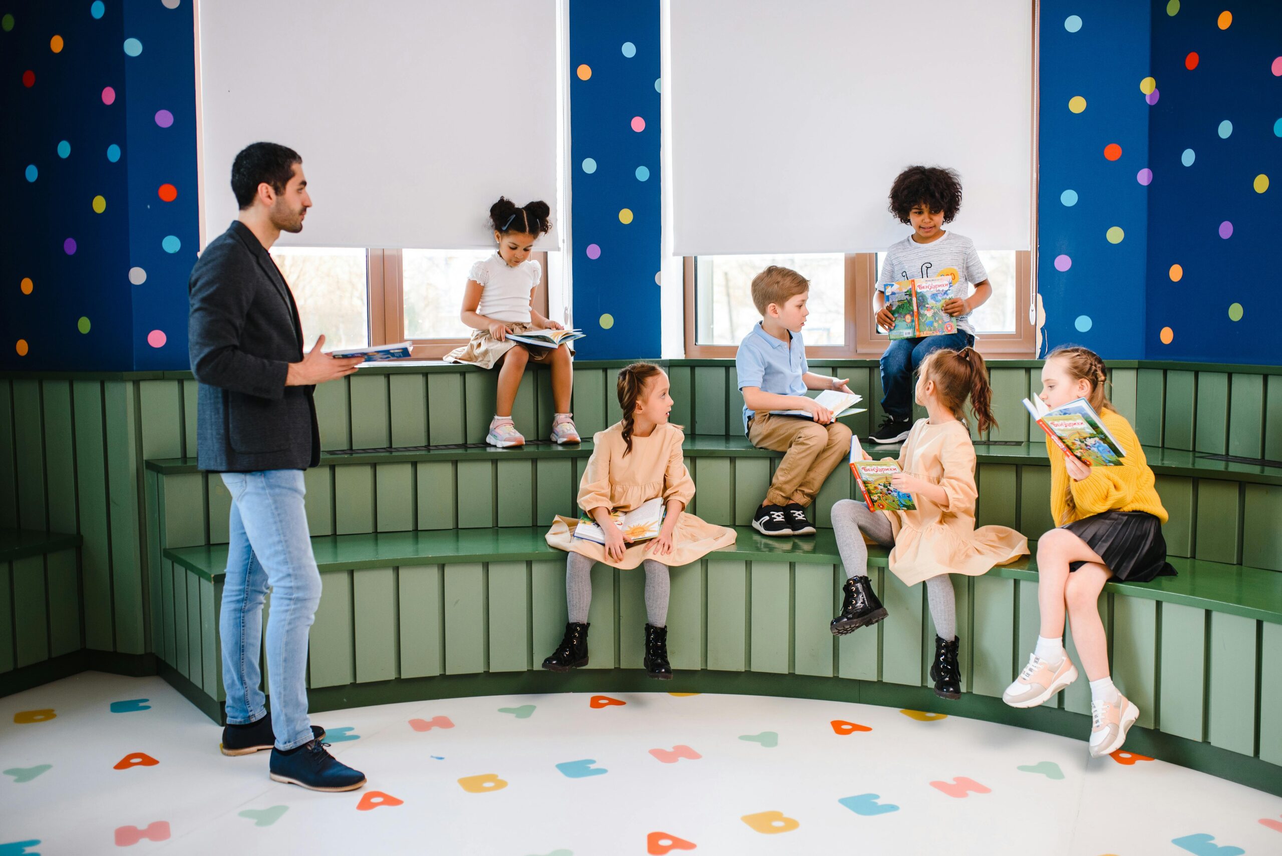 A diverse group of children learning with their teacher in a colorful classroom setting.
